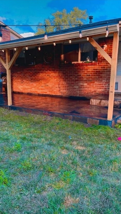 Covered brick patio with stained concrete and string lights